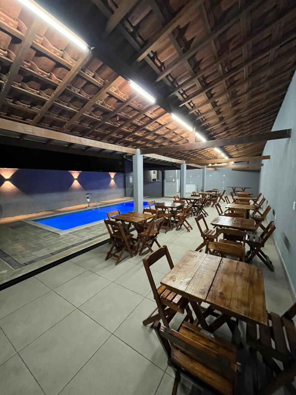 Área da piscina e salão gourmet da Chácara Santa Hermínia à noite